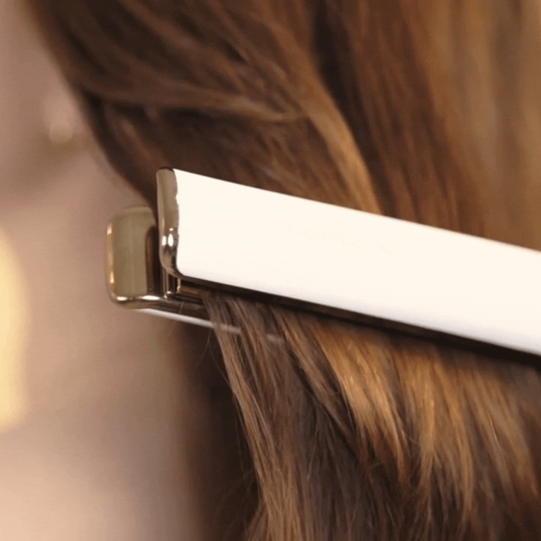 Women straiting her hair with hair straitened after using Heat Protectant Shield