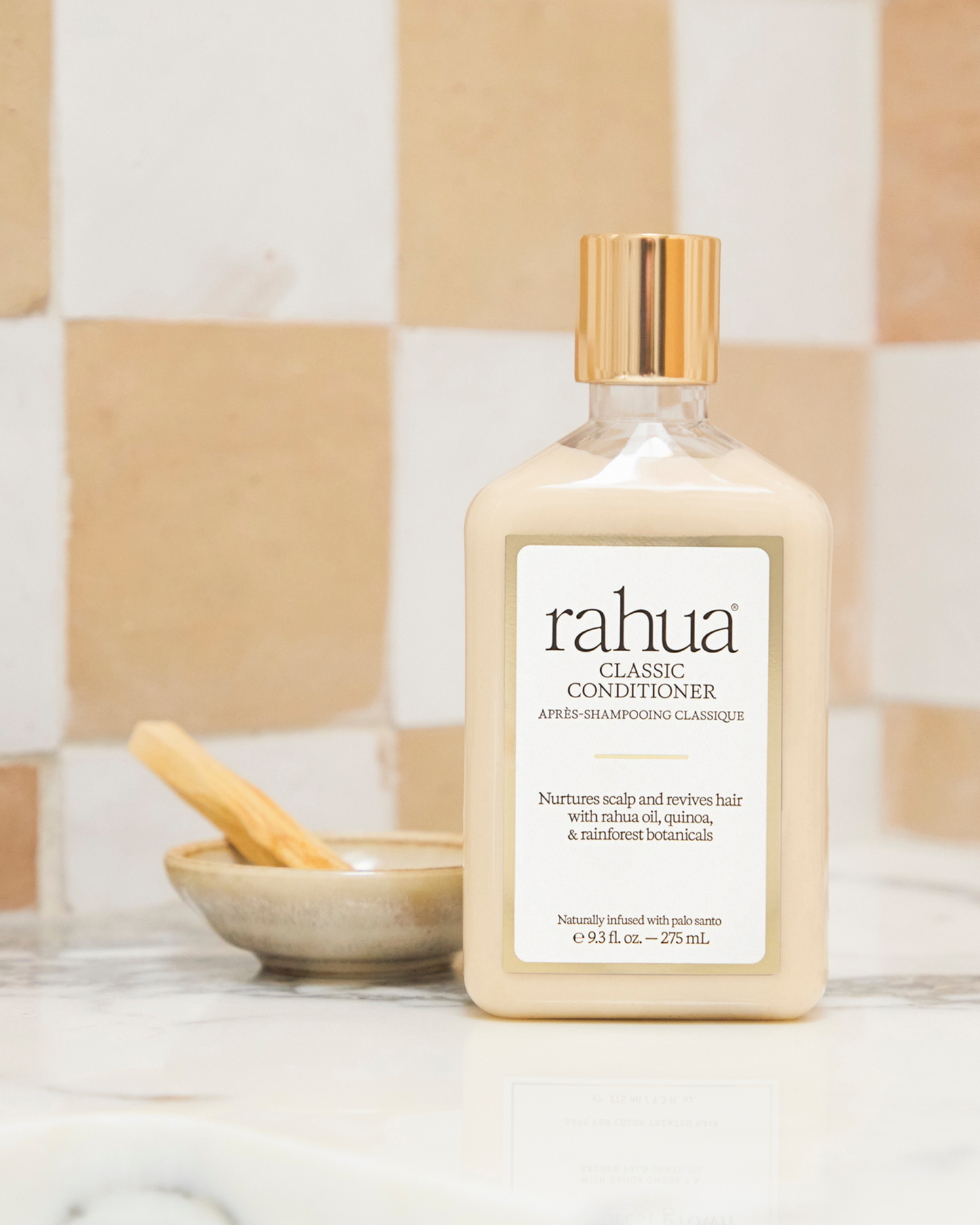 Bottle of rahua classic conditioner on a bathroom counter with a checkered tile background|variant:93-oz