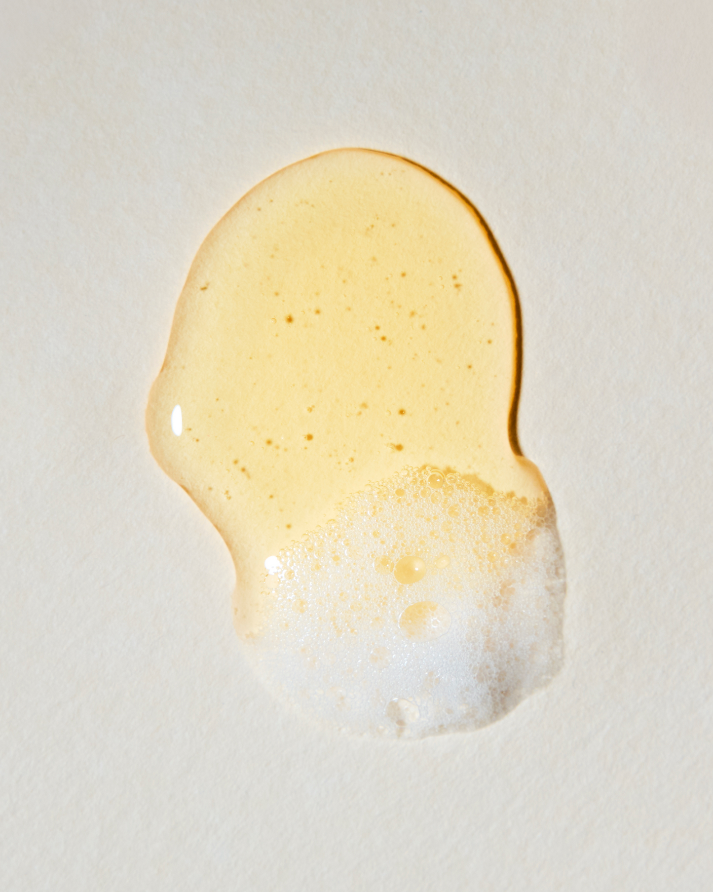 Close-up of a droplet of honey on a light background|variant:93-oz,16-oz,18-oz