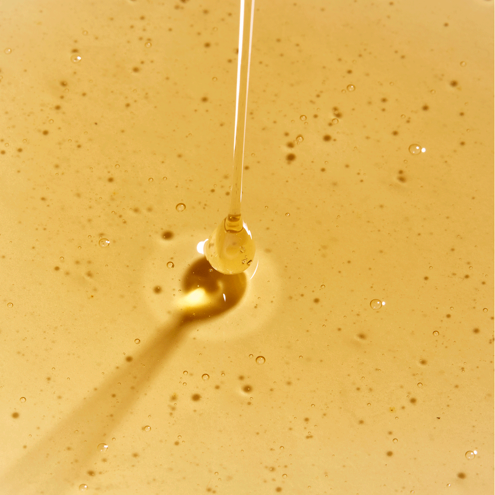 gif of rahua classic shampoo being poured out onto a puddle of classic shampoo on a flat surface to show texture of product shampoo is golden and somewhat thick|variant:93-oz