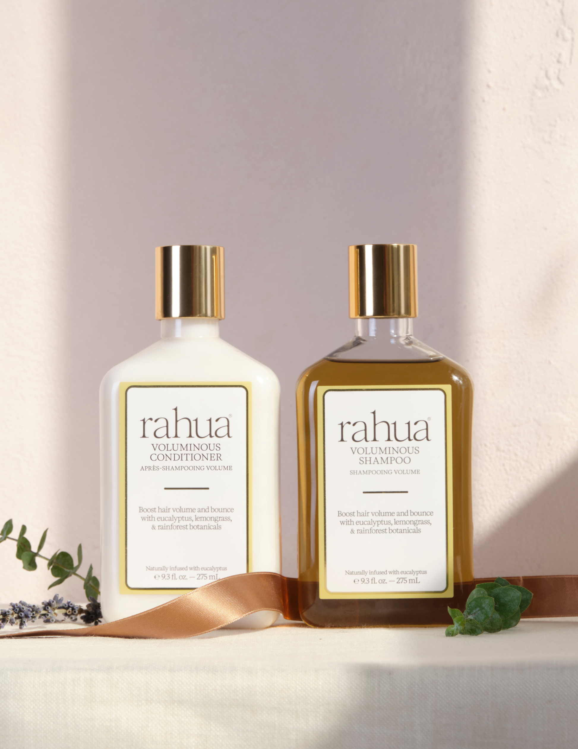 Two bottles of rahua voluminous conditioner and shampoo on a light background|variant:93-oz