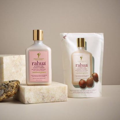 Rahua Hydration conditioner refill pouch on floor and hydration conditioner bottle kept on a marble block