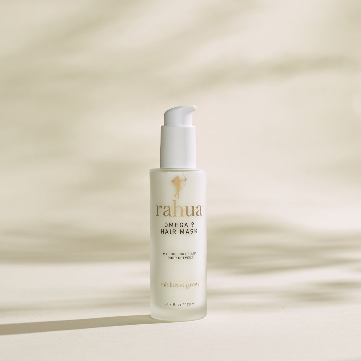 bottle of white product with gold and brown text rahua omega 9 hair mask on a beige background|variant:074-oz